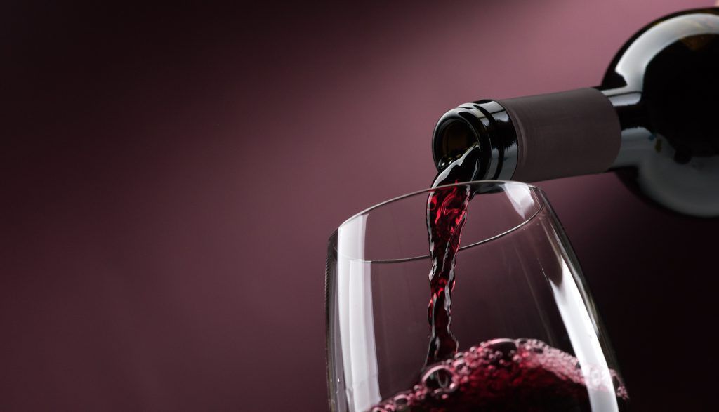 Pouring red wine into a wineglass Pouring red wine into a wineglass